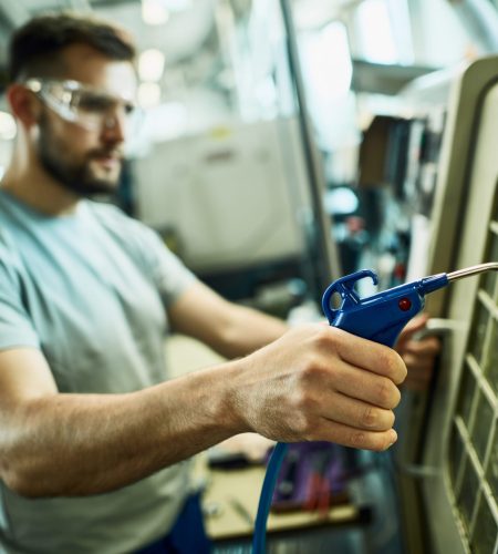 Close-up of manual worker at industrial production line facility.